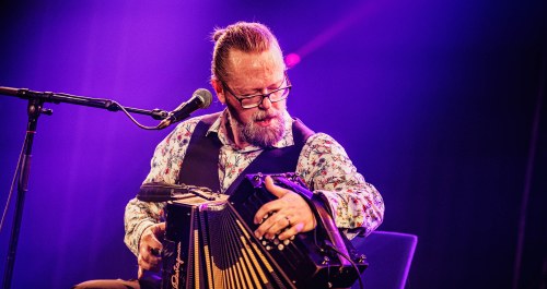 Homme jouant de l'accordéon sur scène. 