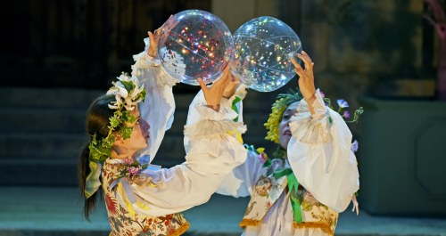 Deux femmes jouant avec des ballons transparents.