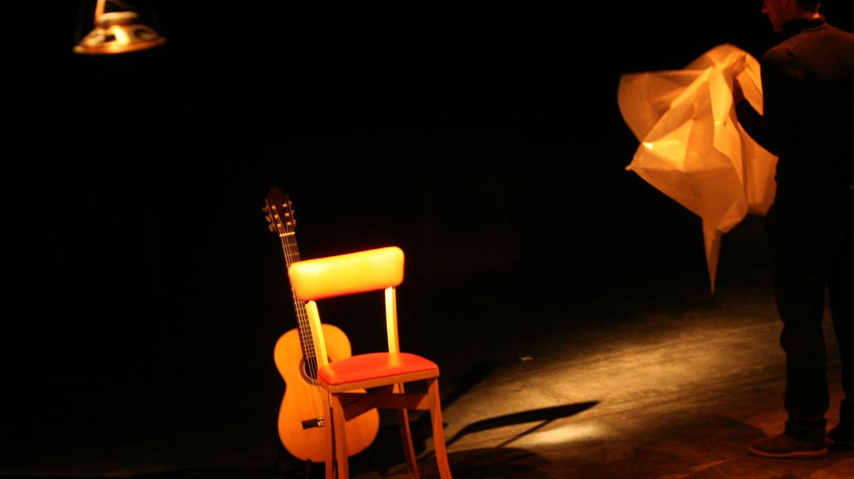 Une guitare et une chaise sur scène